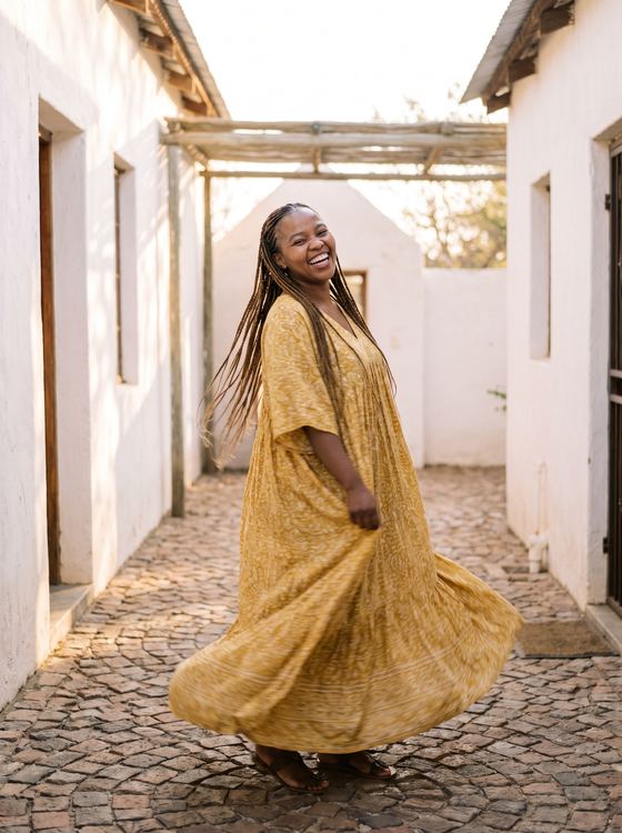 Yellow summer maxi dress in a sunlit courtyard